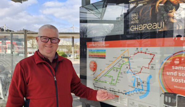 Martin Hinterwinkler, Mobilitätsbeauftragter der Stadt Burghausen, mit der digitalen Anzeigetafel am Busbahnhof © Stadt Burghausen/ebh