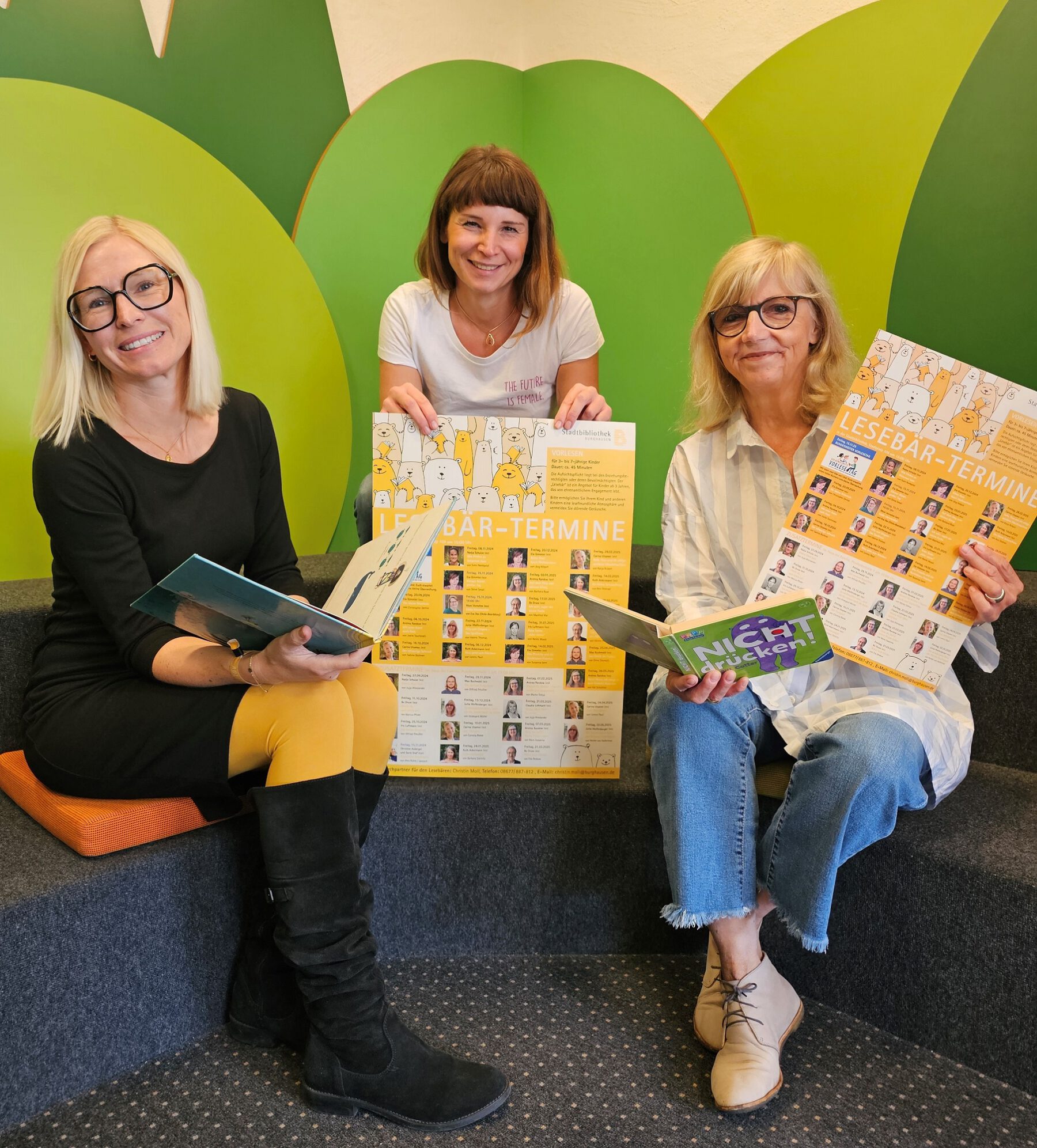 Bibliotheksleiterin Christin Moll (mitte) mit zwei der ehrenamtlichen Vorleserinnen, Carina Ulsamer (l.) und Jutta Wolfersberger. Fotocredit: Stadt Burghausen/ebh