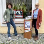 In der Stadtbibliothek ist das Gespenst Toni derzeit nicht zu übersehen. Christin Moll (li.), Leiterin der Stadtbibliothek, und Mitarbeiterin Rosi Pfeifenthaler am Startpunkt des Bilderbuch-Spaziergangs Fotocredit: Stadt Burghausen/sast