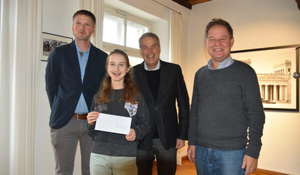 Erster Bürgermeister Florian Schneider (v.r.) gratulierte Schulleiter Christian Wagner sowie Lehrer Benedikt Waas zu dem erfolgreichen Projekt und sprach mit Schülerin Cosima Enderle über ihre literarischen Ambitionen. Als kleine Aufmerksamkeit überreichte das Stadtoberhaupt Burghauser 10er, womit sich die 14-Jährige beispielsweise Bücher im Burghauser Einzelhandel kaufen kann. Fotocredit: Stadt Burghausen / Königseder