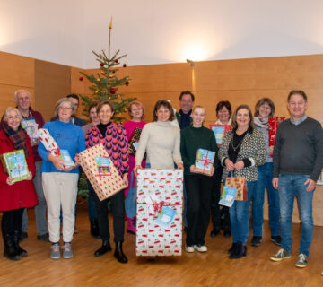 Alle Akteure kommen Jahr für Jahr zusammen und nehmen für ihre Einrichtung die Geschenke entgegen. Erster Bürgermeister Florian Schneider, Magdalena Weber als Leiterin des Bürgerhauses, Christin Moll als Leiterin der Stadtbibliothek und Lissi Rummert als Leiterin des Sozialamtes waren von Seiten der Stadt dabei und übergaben die 194 Geschenke. Foto: Stadt Burghausen / Königseder